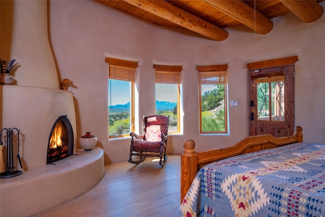 bedroom featuring wood-type flooring, a mountain view, beam ceiling, and wooden ceiling