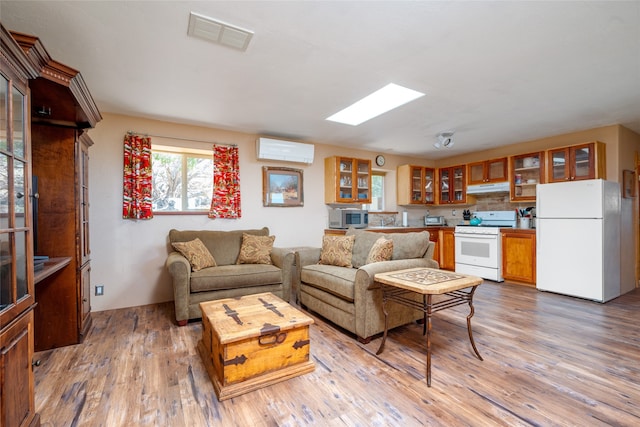 living room featuring wood-type flooring and a wall unit AC