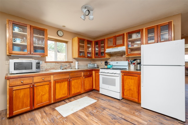 kitchen featuring light hardwood / wood-style floors, sink, white appliances, and decorative backsplash