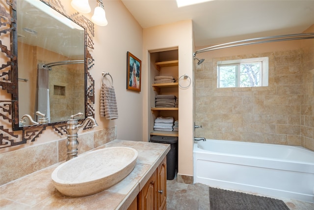 bathroom featuring tiled shower / bath combo and vanity