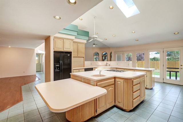 kitchen featuring black appliances, kitchen peninsula, a center island, and ceiling fan