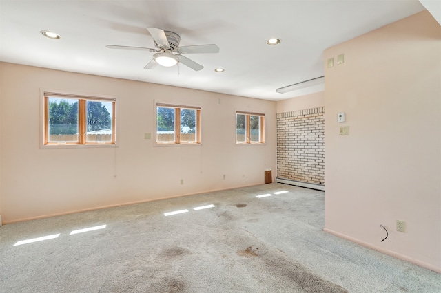 carpeted spare room with ceiling fan and a baseboard heating unit