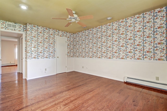 spare room with wood-type flooring, ceiling fan, and baseboard heating