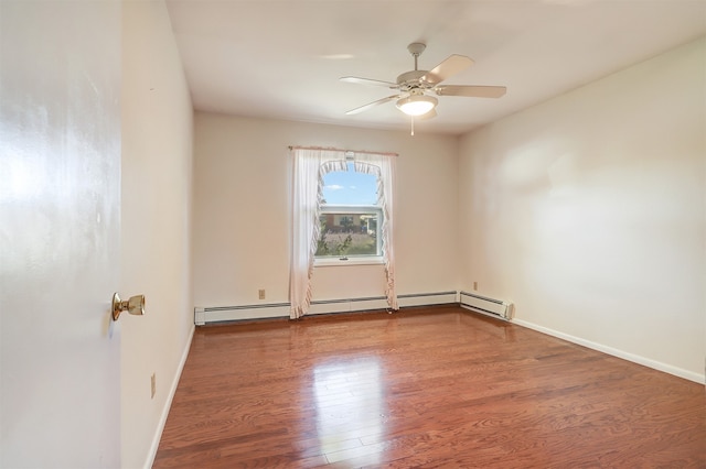 spare room featuring ceiling fan, baseboard heating, and wood-type flooring