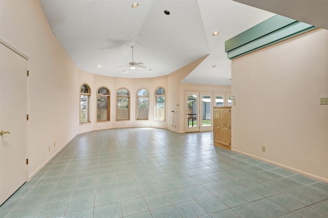 unfurnished living room featuring french doors, a high ceiling, ceiling fan, and light tile patterned flooring