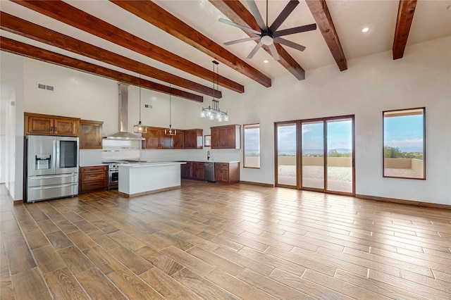 kitchen featuring stainless steel appliances, sink, exhaust hood, pendant lighting, and a kitchen island