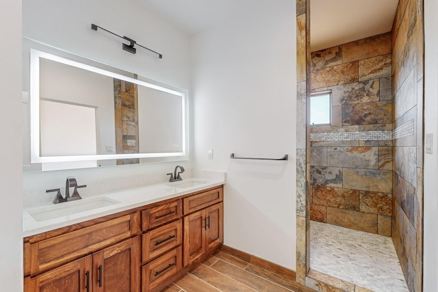 bathroom featuring a tile shower and vanity