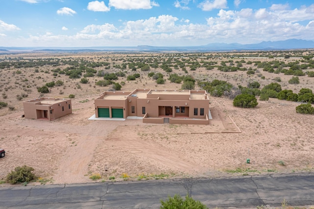 adobe home featuring a mountain view and a garage