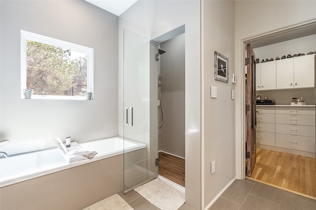 bathroom featuring tile patterned flooring and shower with separate bathtub