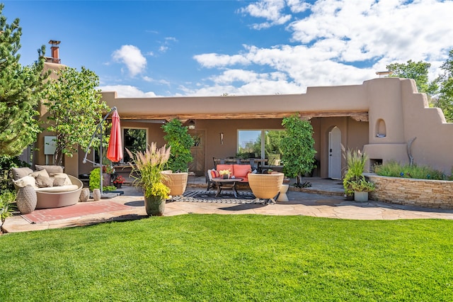 back of house featuring a lawn, an outdoor living space, and a patio