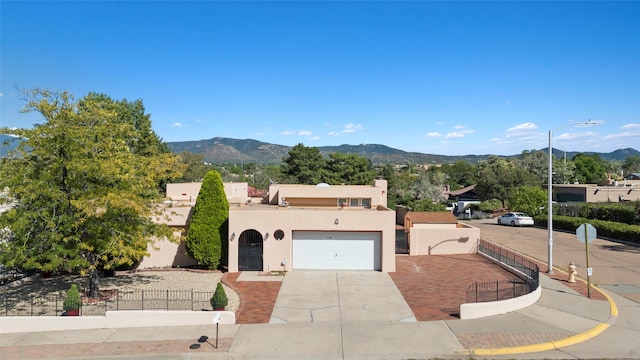 pueblo revival-style home featuring a mountain view and a garage