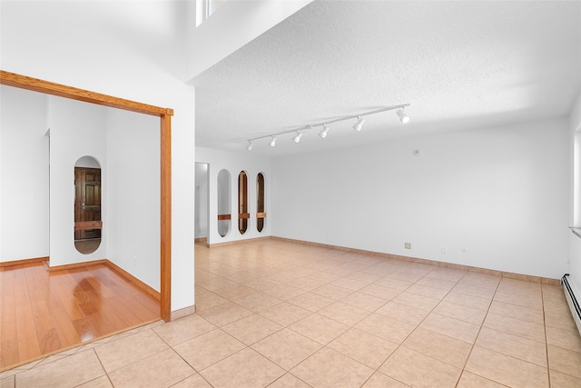 empty room featuring light wood-type flooring and a textured ceiling