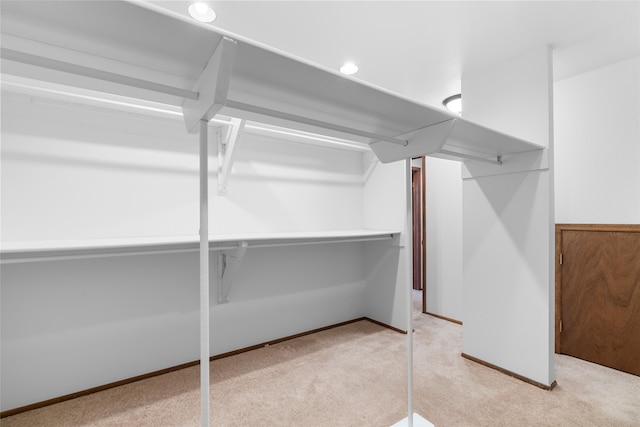 spacious closet featuring light colored carpet