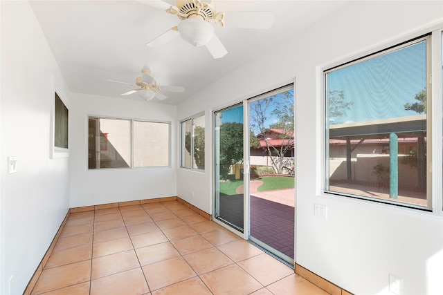 unfurnished sunroom featuring ceiling fan