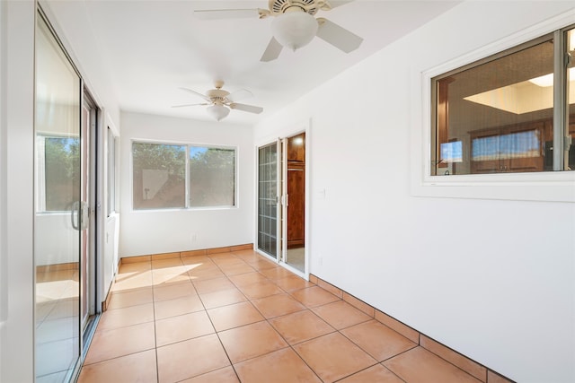 empty room featuring ceiling fan and light tile patterned floors