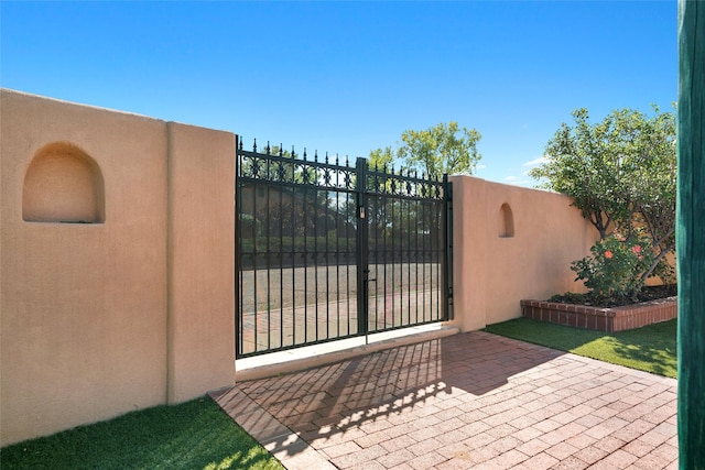 view of gate featuring a patio