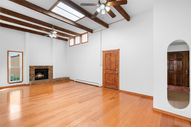 unfurnished living room featuring a high ceiling, baseboard heating, and light hardwood / wood-style flooring