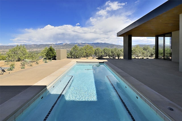 view of swimming pool featuring a mountain view and a patio