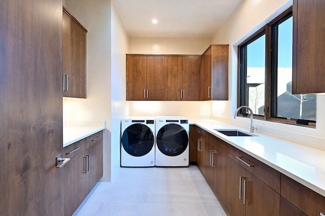 laundry room with washer and clothes dryer, cabinets, and sink