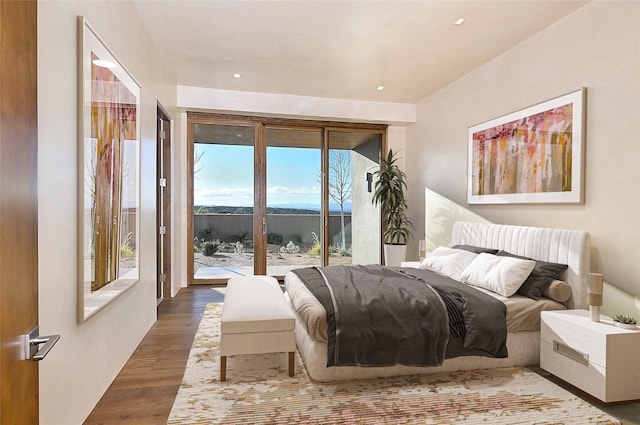 bedroom featuring access to exterior, wood-type flooring, and multiple windows