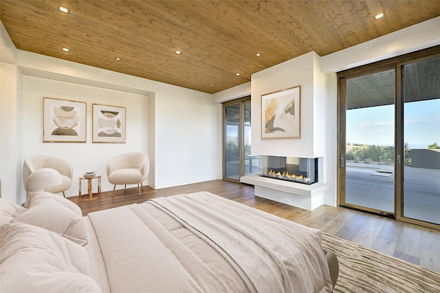 bedroom featuring hardwood / wood-style flooring, a multi sided fireplace, wooden ceiling, and access to outside