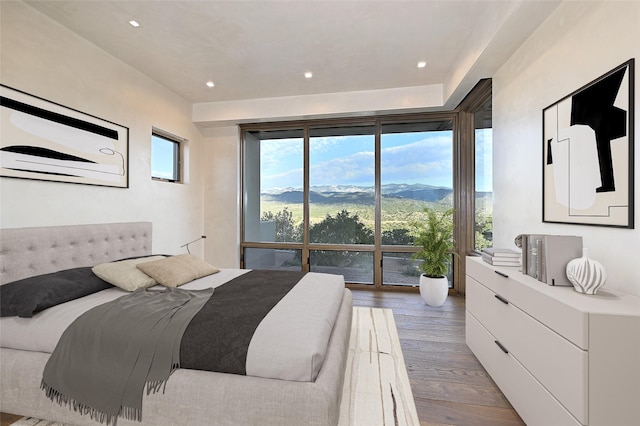 bedroom with hardwood / wood-style floors and a mountain view