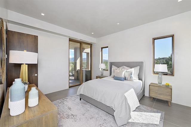 bedroom featuring multiple windows, tile patterned flooring, and access to outside