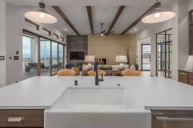 kitchen featuring a center island with sink, decorative light fixtures, and a wealth of natural light