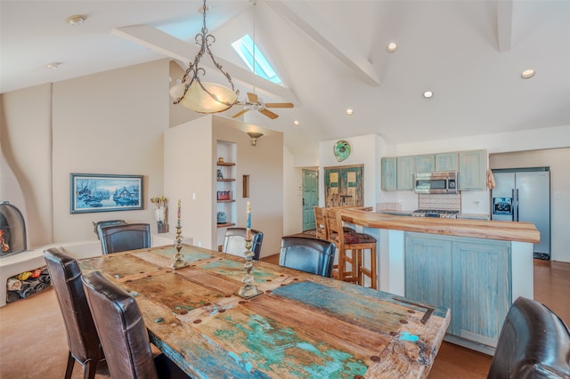 dining area featuring beamed ceiling, a skylight, high vaulted ceiling, and ceiling fan