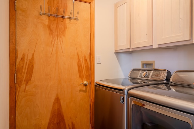 laundry area featuring washing machine and clothes dryer and cabinets