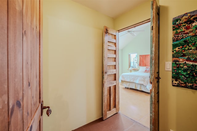 hallway with lofted ceiling and light tile patterned flooring