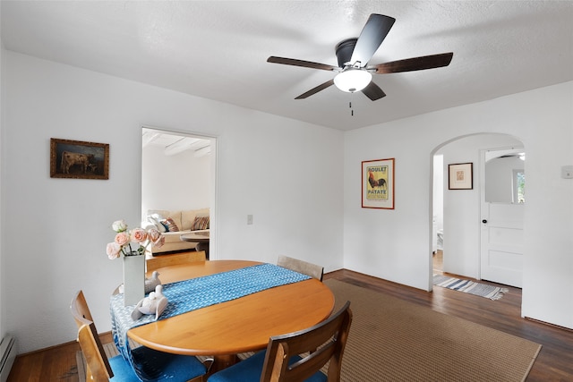 dining space featuring ceiling fan, a textured ceiling, baseboard heating, and dark hardwood / wood-style floors