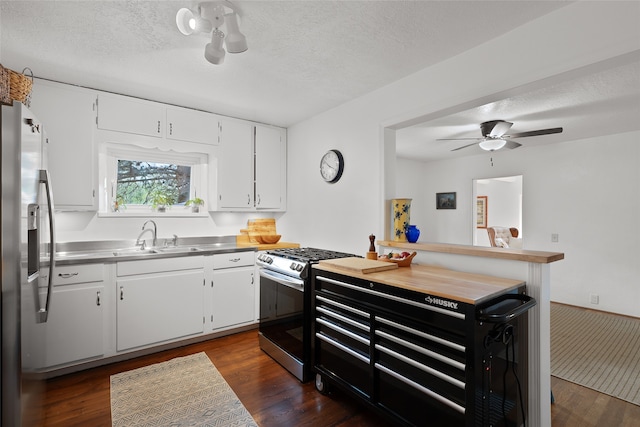 kitchen featuring appliances with stainless steel finishes, dark hardwood / wood-style floors, sink, and white cabinetry