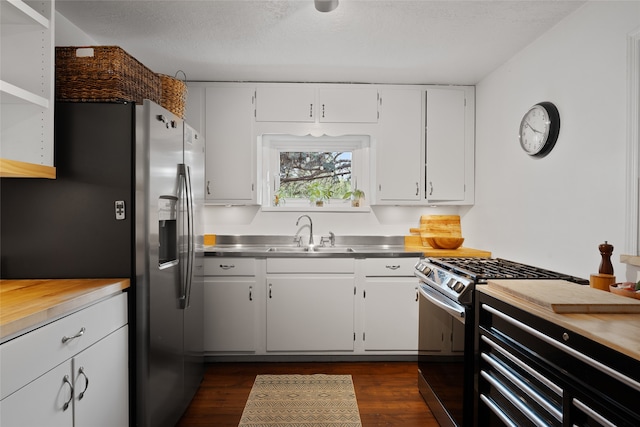 kitchen with sink, white cabinetry, stainless steel counters, appliances with stainless steel finishes, and dark hardwood / wood-style floors