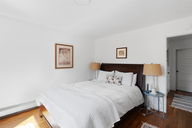 bedroom featuring dark hardwood / wood-style flooring and a baseboard heating unit