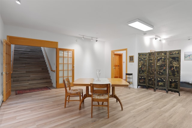 dining room with light hardwood / wood-style floors and rail lighting