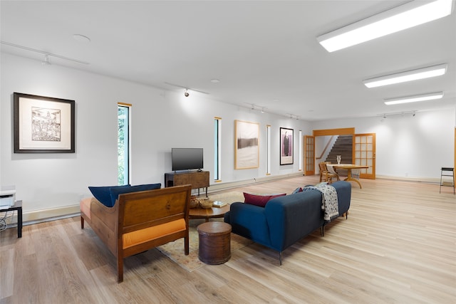 living room featuring light wood-type flooring and track lighting