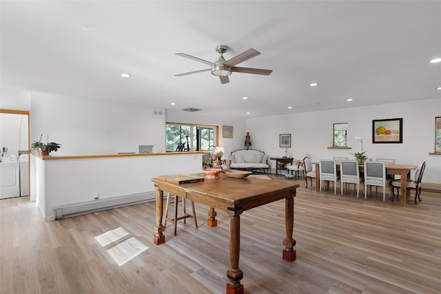 recreation room with a baseboard radiator, light wood-type flooring, ceiling fan, and washer and dryer