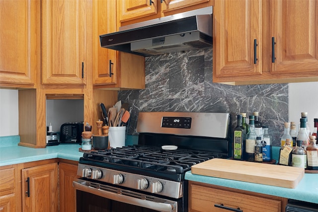 kitchen featuring ventilation hood, backsplash, and stainless steel range with gas cooktop