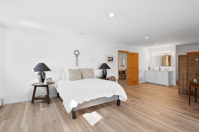 bedroom featuring light wood-type flooring and ensuite bathroom