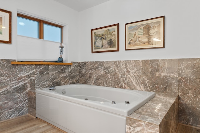 bathroom with a bath, wood-type flooring, and tile walls