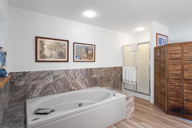 bathroom with hardwood / wood-style floors and separate shower and tub