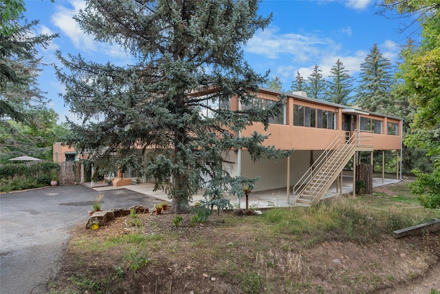 view of front facade with a sunroom and a patio