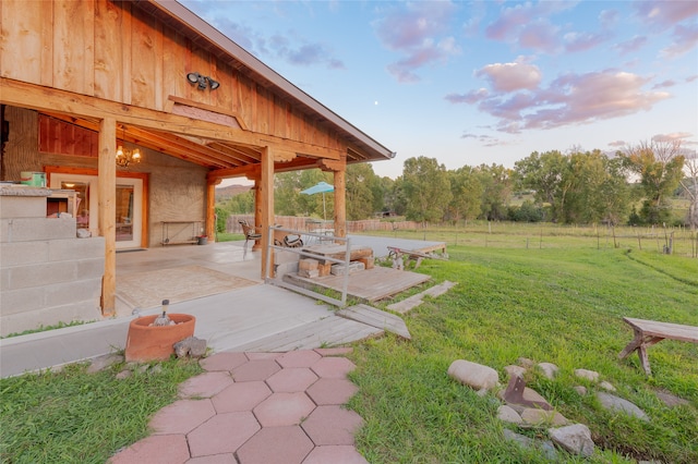 yard at dusk featuring a patio area