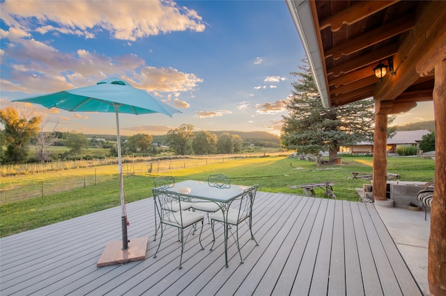 deck at dusk featuring a yard