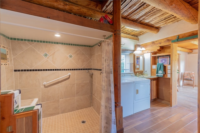 bathroom featuring vanity, beamed ceiling, hardwood / wood-style flooring, washer and clothes dryer, and a shower with curtain