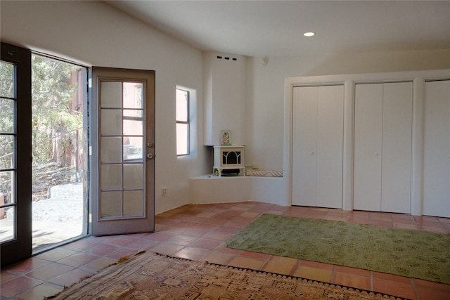 entryway with lofted ceiling and light tile patterned flooring