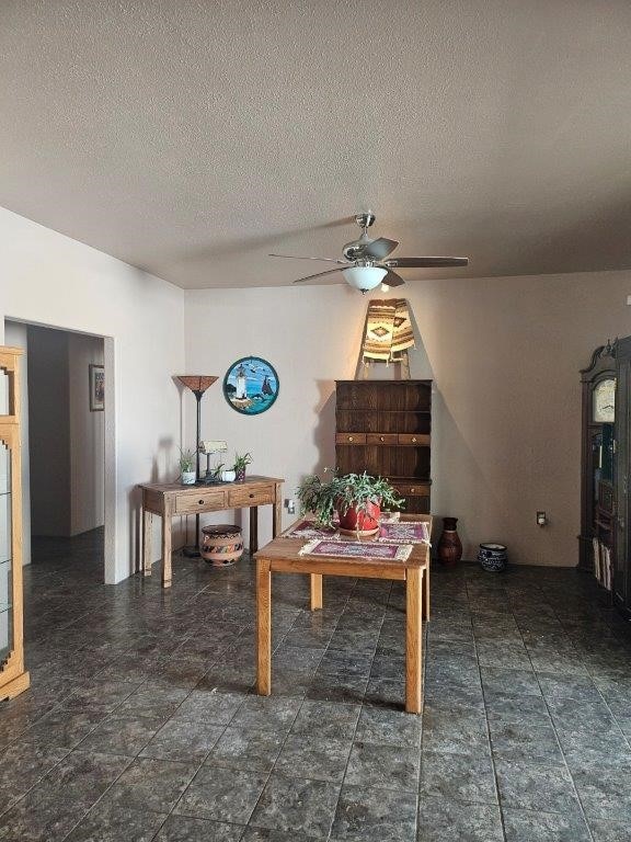 dining space with a textured ceiling and ceiling fan