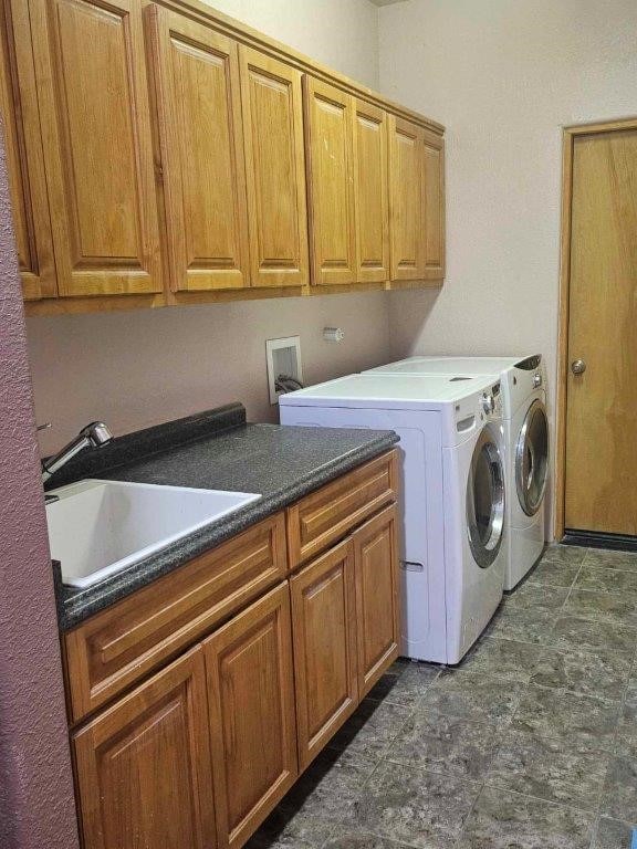 laundry room featuring cabinets, sink, and washer and dryer