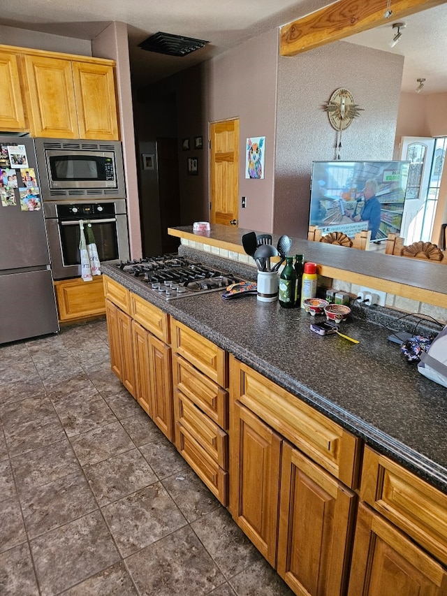 kitchen featuring dark tile patterned flooring and appliances with stainless steel finishes